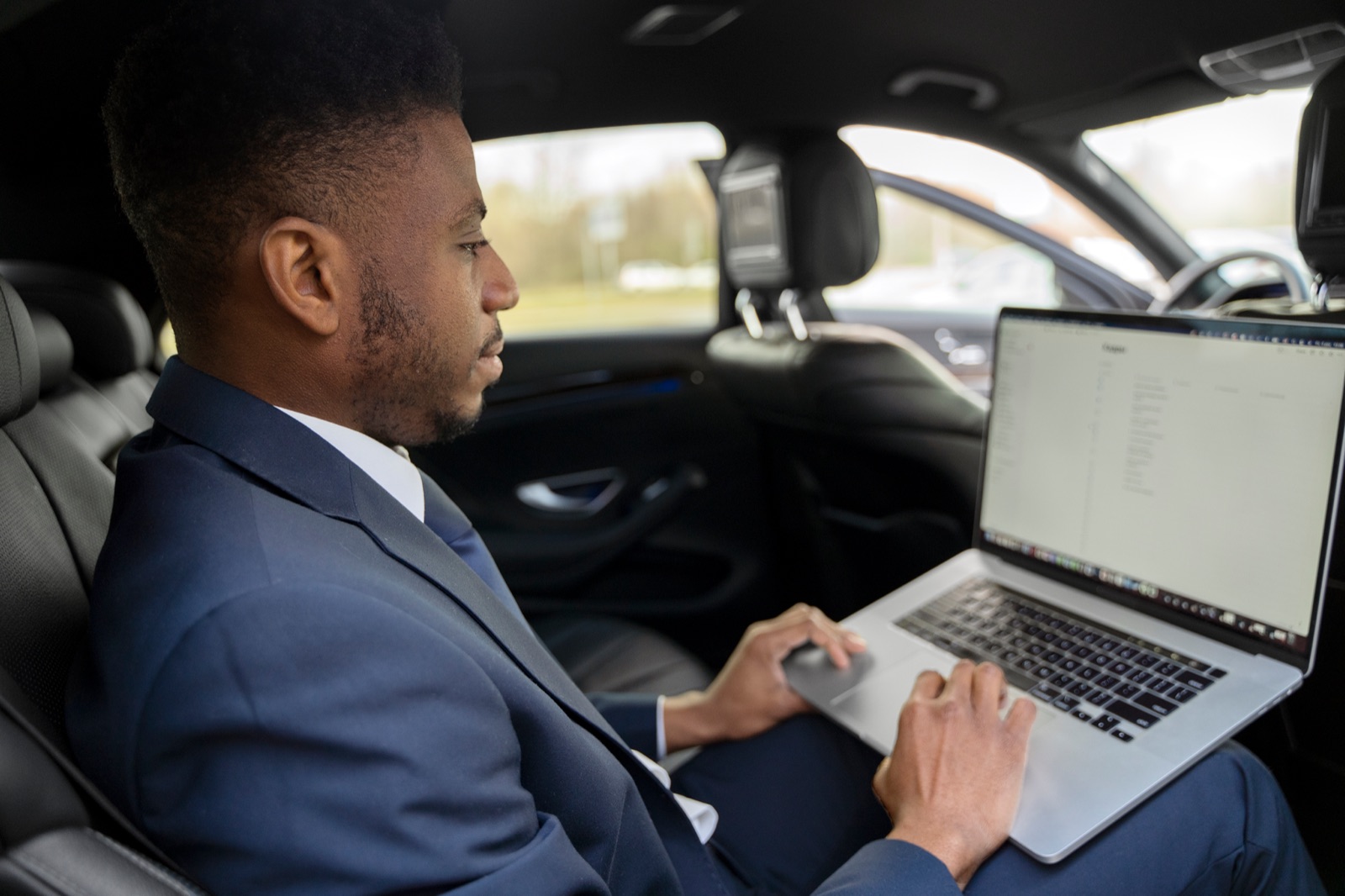 A rider working on a laptop on the way to a meeting
